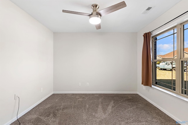 carpeted spare room featuring baseboards, visible vents, and a ceiling fan