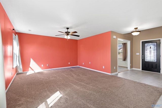 unfurnished living room featuring a ceiling fan, carpet, and baseboards