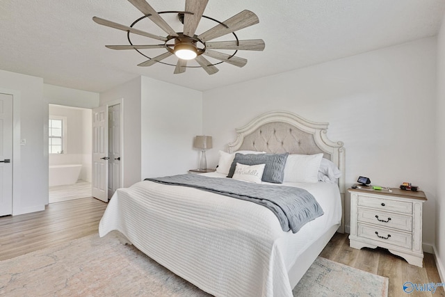 bedroom with ceiling fan, connected bathroom, and wood-type flooring