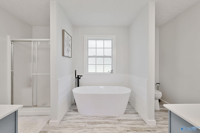 full bathroom featuring tile walls, separate shower and tub, and vanity