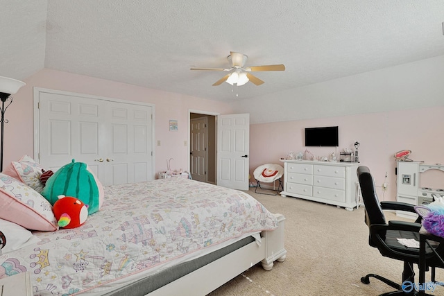 carpeted bedroom featuring a closet, a textured ceiling, a ceiling fan, and vaulted ceiling