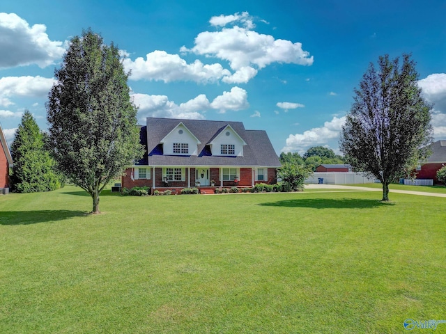 cape cod home with a front yard and brick siding