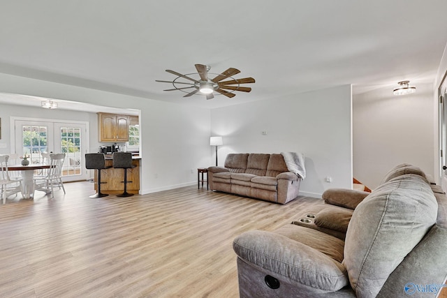 living room featuring ceiling fan, french doors, and light wood-type flooring