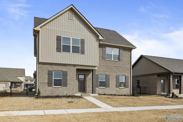 townhome / multi-family property featuring brick siding, board and batten siding, a shingled roof, and fence