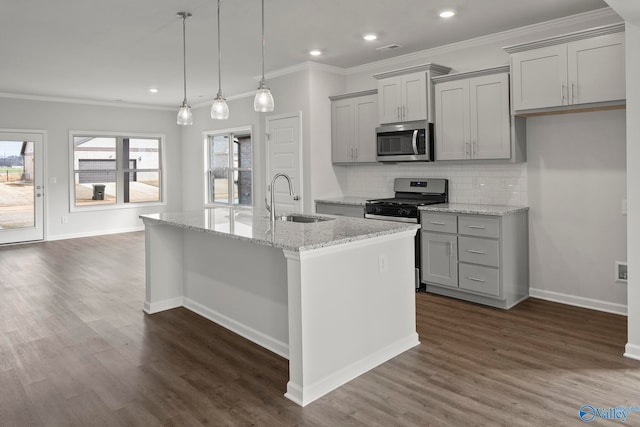 kitchen featuring a center island with sink, stainless steel appliances, dark wood-type flooring, and sink