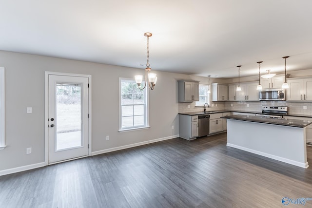 kitchen featuring gray cabinetry, sink, decorative light fixtures, and stainless steel appliances