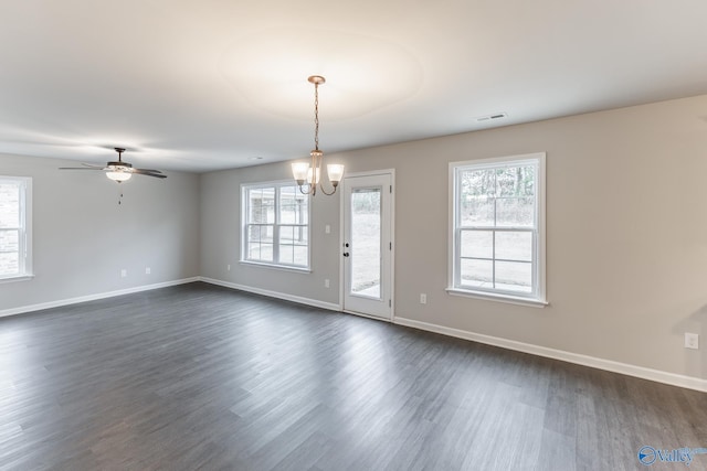 spare room with dark hardwood / wood-style flooring and ceiling fan with notable chandelier