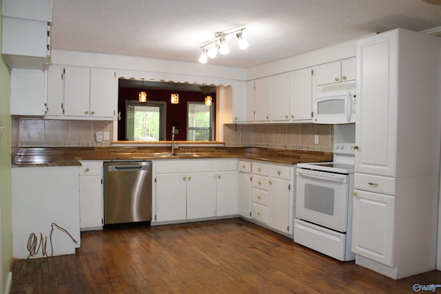 kitchen featuring white cabinets, decorative backsplash, a sink, and white appliances
