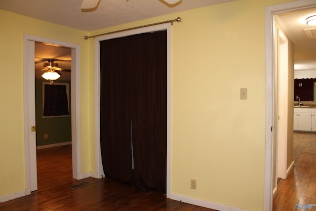 unfurnished bedroom featuring visible vents, baseboards, wood finished floors, and a sink