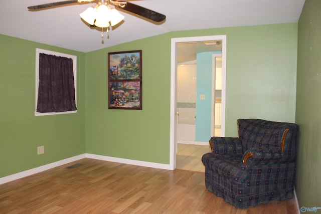 sitting room featuring lofted ceiling, a ceiling fan, baseboards, and wood finished floors
