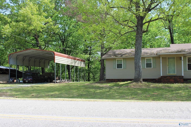 exterior space with a carport, driveway, and a yard