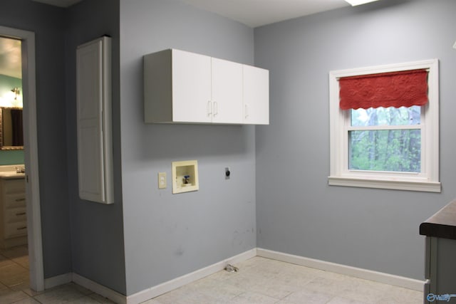 laundry area with a sink, hookup for an electric dryer, hookup for a washing machine, baseboards, and cabinet space