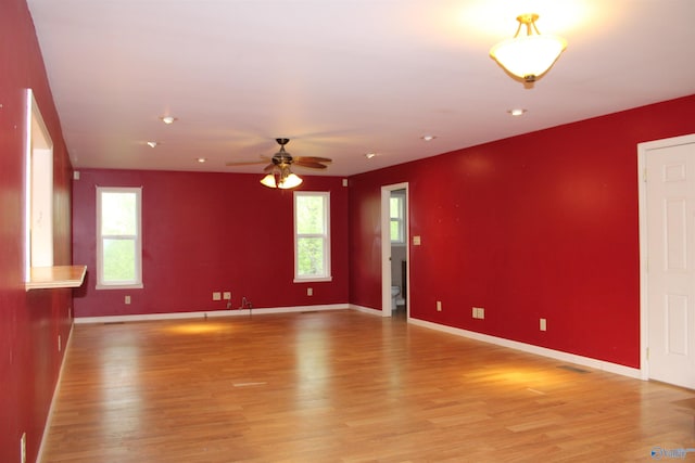 unfurnished living room featuring light wood finished floors, baseboards, and ceiling fan