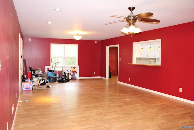interior space with light wood finished floors, baseboards, and ceiling fan