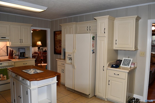 kitchen with butcher block countertops, white appliances, light tile patterned floors, ornamental molding, and a textured ceiling