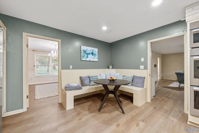 dining room featuring light wood-type flooring, breakfast area, and wainscoting