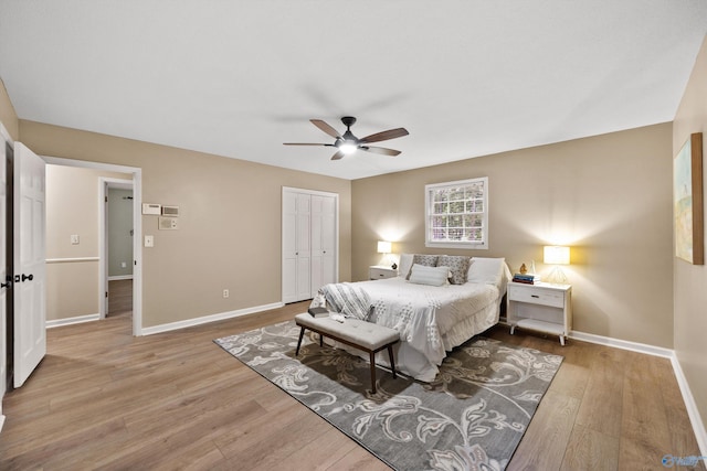 bedroom with wood finished floors, a closet, a ceiling fan, and baseboards
