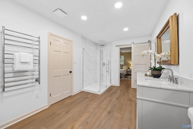 bathroom featuring wood finished floors, a marble finish shower, vanity, visible vents, and recessed lighting