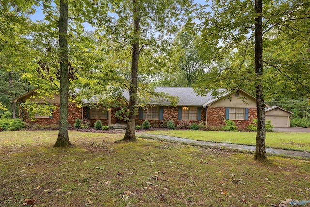 ranch-style home featuring a garage, an outbuilding, a front lawn, and brick siding