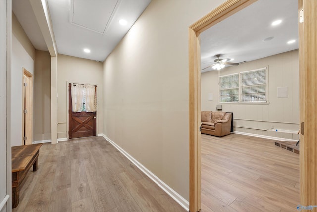 corridor with attic access, light wood finished floors, baseboards, and recessed lighting