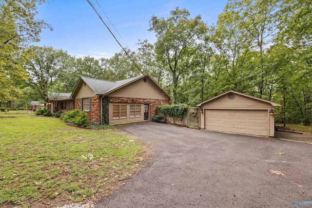 view of property exterior featuring brick siding, a detached garage, and a lawn