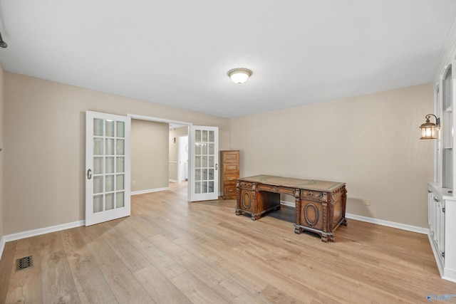 office space with light wood-style flooring, visible vents, baseboards, and french doors