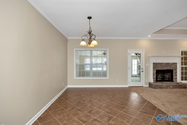 unfurnished dining area featuring dark colored carpet, a fireplace, ornamental molding, and an inviting chandelier