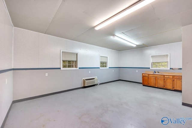 156 San Leonardo Way, Huntsville, AL 35811 - empty room with concrete flooring, baseboards, a wall mounted AC, and a sink