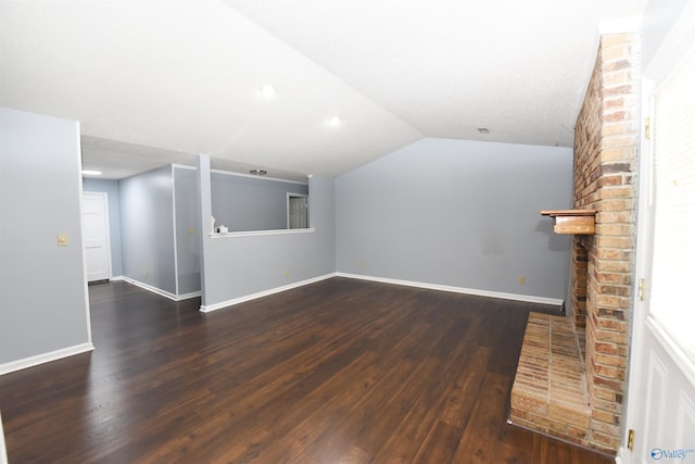 1208 SE Teenajo Dr SE, Huntsville, AL 35803 - unfurnished living room with wood finished floors, lofted ceiling, and a fireplace