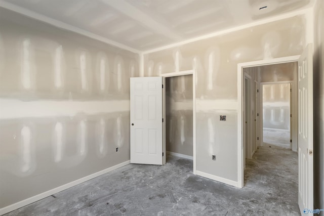 unfurnished bedroom featuring concrete floors and baseboards