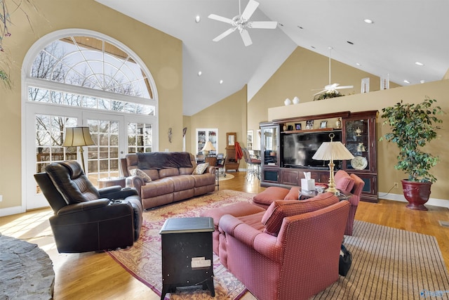 living room featuring ceiling fan, high vaulted ceiling, light wood-type flooring, and french doors