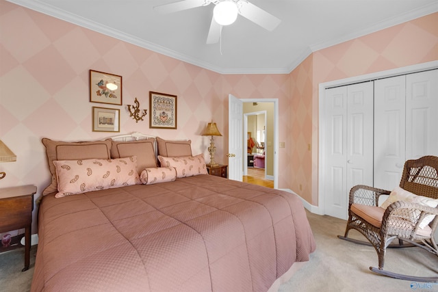 carpeted bedroom with ceiling fan, ornamental molding, and a closet