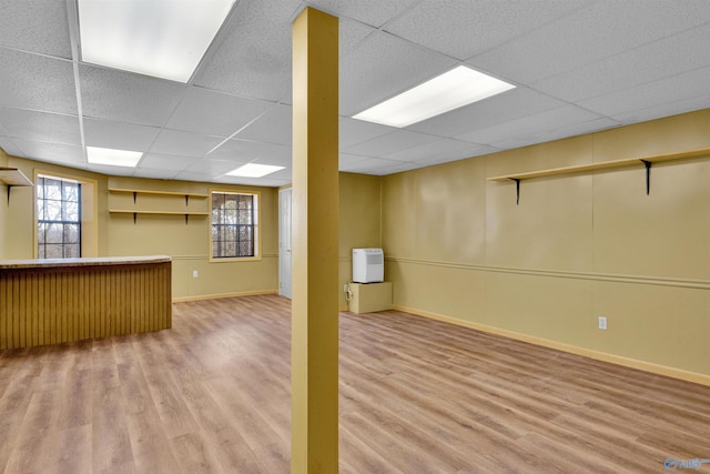 basement with hardwood / wood-style flooring, plenty of natural light, and a paneled ceiling