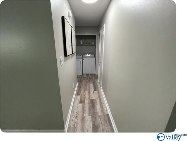 corridor with hardwood / wood-style flooring and washer and clothes dryer