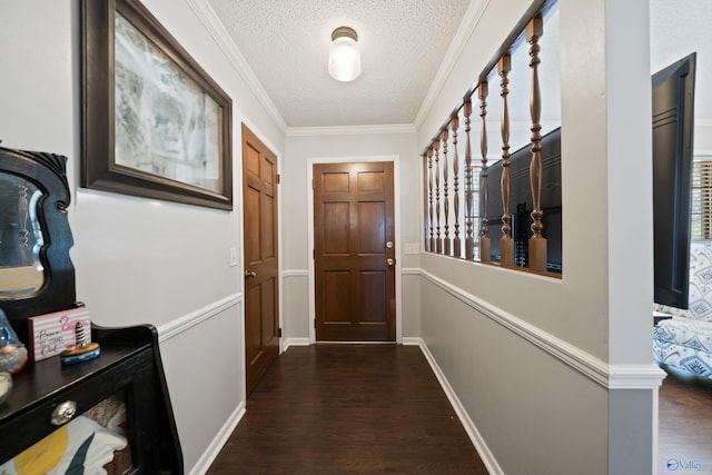 doorway featuring dark wood-style floors, crown molding, a textured ceiling, and baseboards