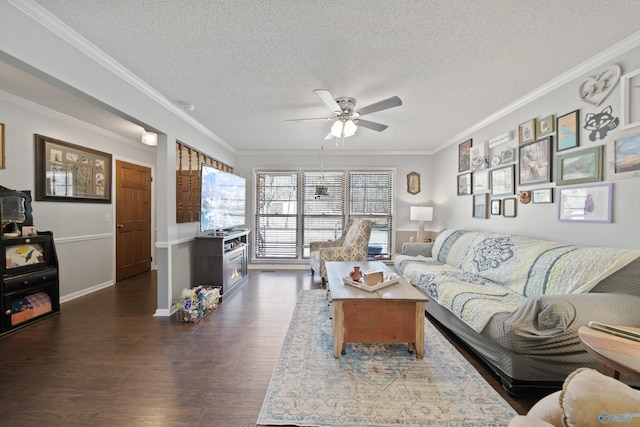 living room featuring dark wood-style floors, a textured ceiling, a ceiling fan, and crown molding