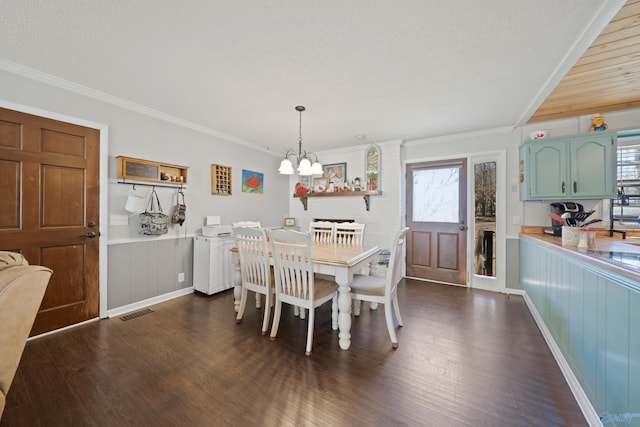 dining room with ornamental molding, dark wood finished floors, visible vents, and an inviting chandelier