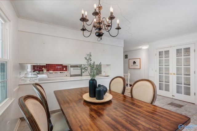dining space with a chandelier and french doors