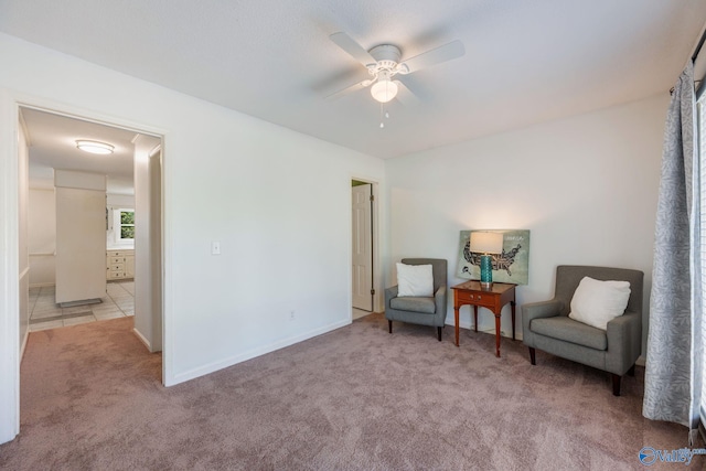 sitting room featuring baseboards, a ceiling fan, and carpet floors