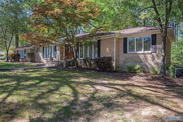view of front of property featuring brick siding, a front lawn, and crawl space