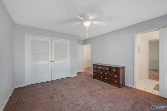 unfurnished bedroom with a closet, baseboards, a ceiling fan, and carpet
