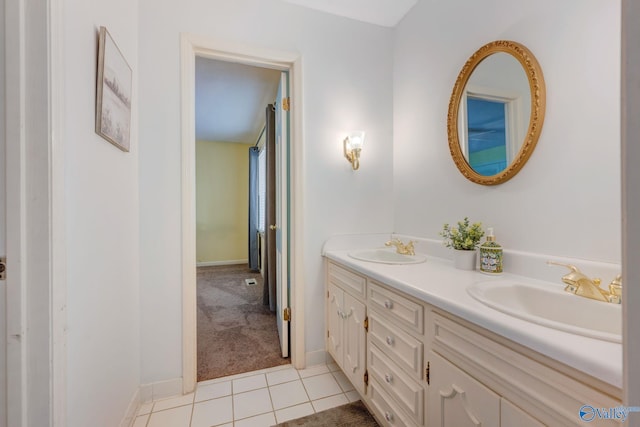 full bathroom featuring tile patterned flooring, double vanity, baseboards, and a sink