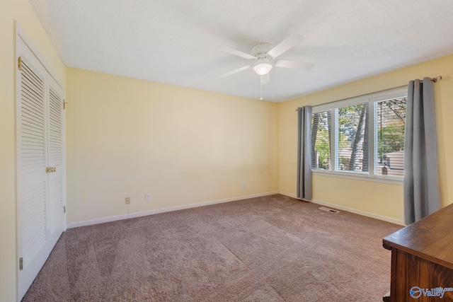unfurnished bedroom with visible vents, baseboards, carpet flooring, and ceiling fan