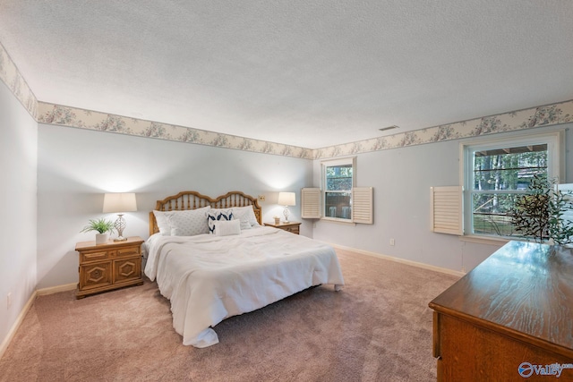 bedroom with carpet, multiple windows, baseboards, and a textured ceiling