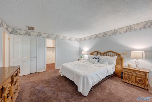 bedroom with a textured ceiling, baseboards, visible vents, and carpet floors