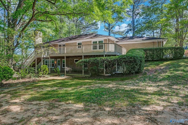 rear view of property featuring a wooden deck, a lawn, brick siding, a chimney, and stairs