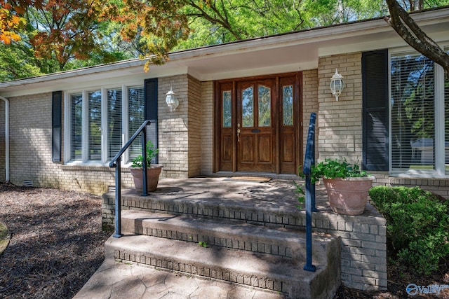 doorway to property with brick siding