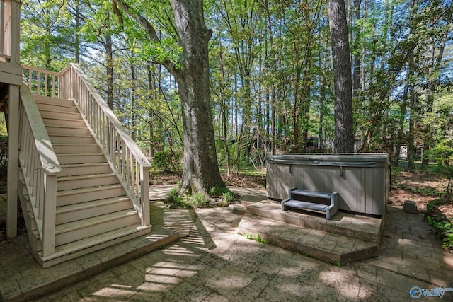 view of patio featuring stairs and a hot tub