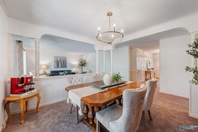 carpeted dining room featuring a chandelier, baseboards, and decorative columns
