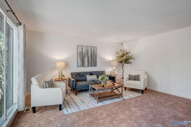 carpeted living area featuring baseboards and visible vents